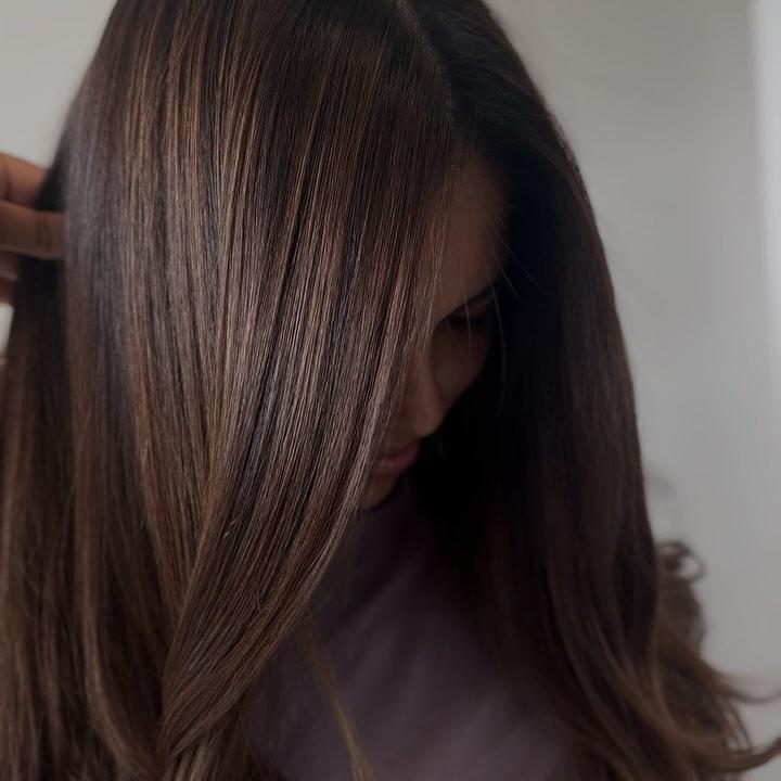 Dark hair blown out to a straight, mirror-like shine